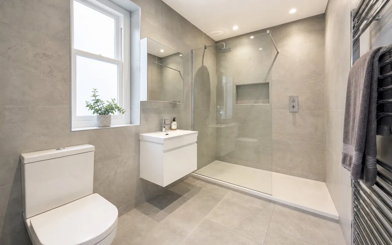 Refurbished bathroom after completion: new suite, fully tiled walls and floor
